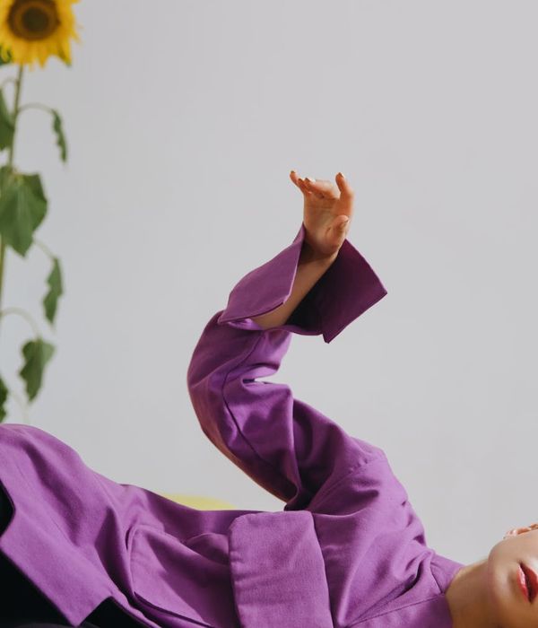 Woman in a graceful yoga pose in a studio with green tones.